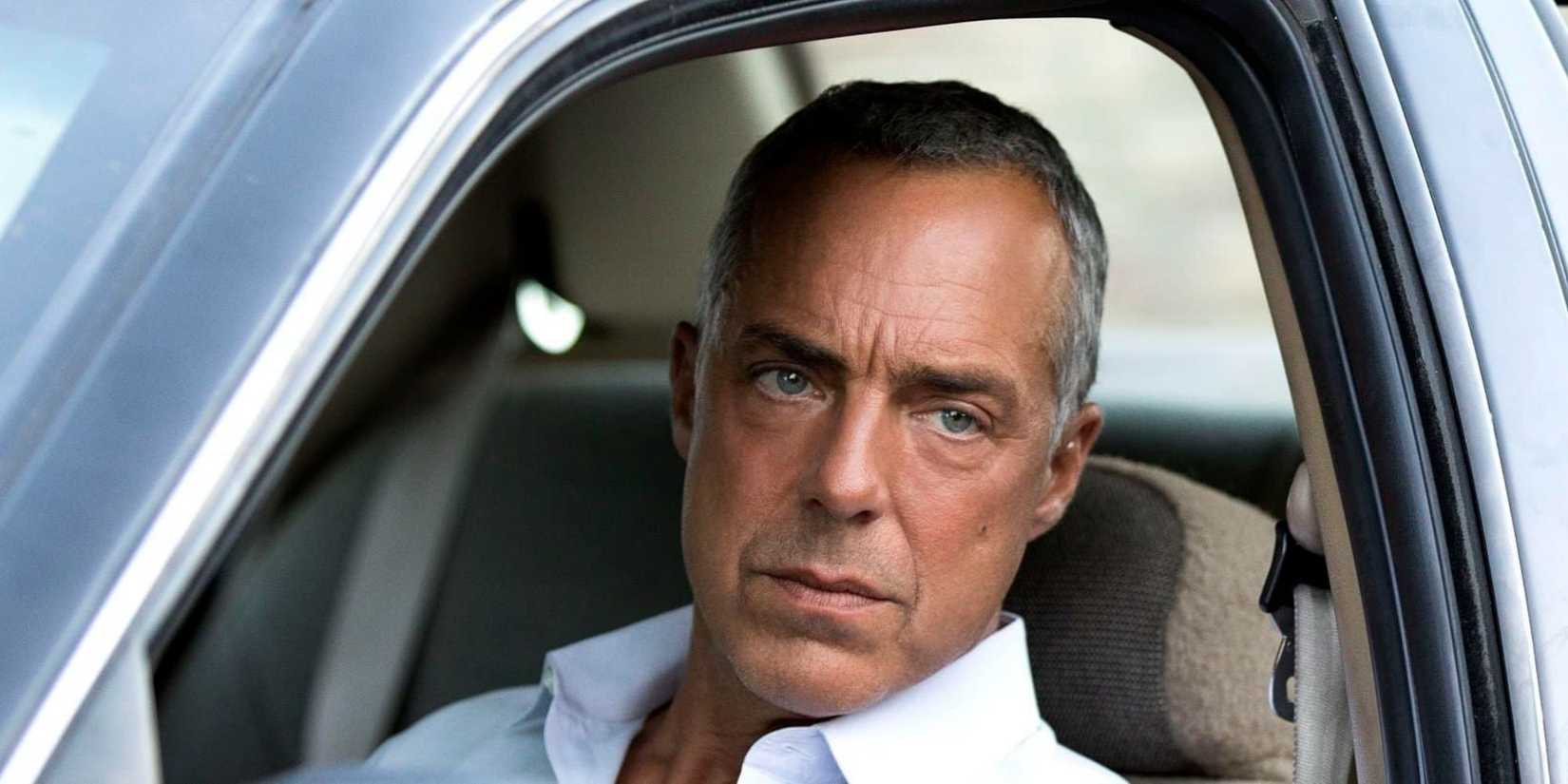 Bosch (тιтus Welliver) leaning out a car and staring at something in Bosch.