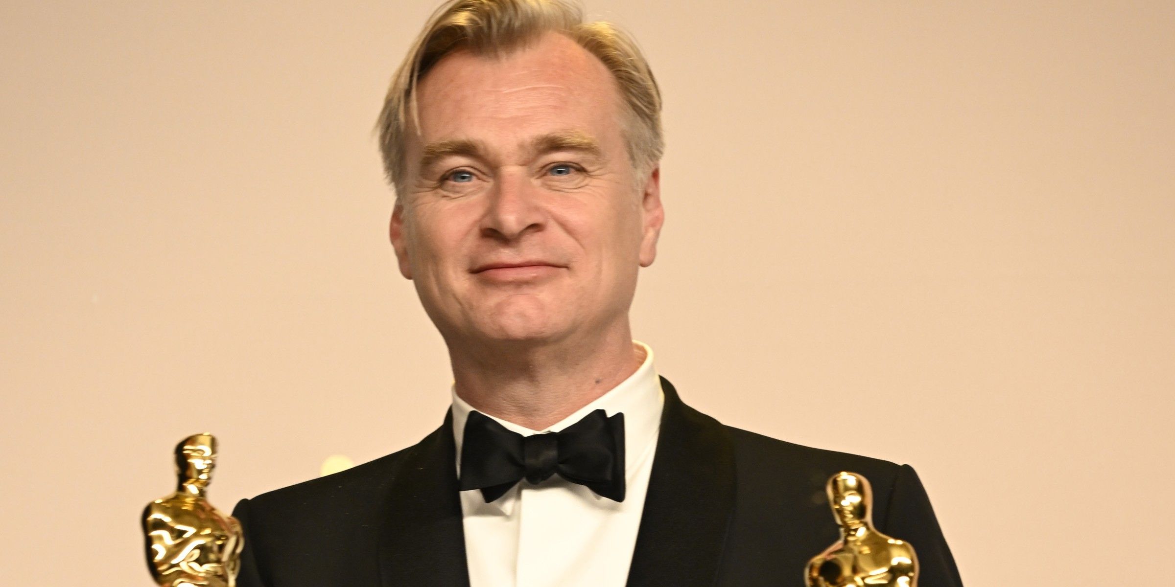 Christopher Nolan holding Oscars statues