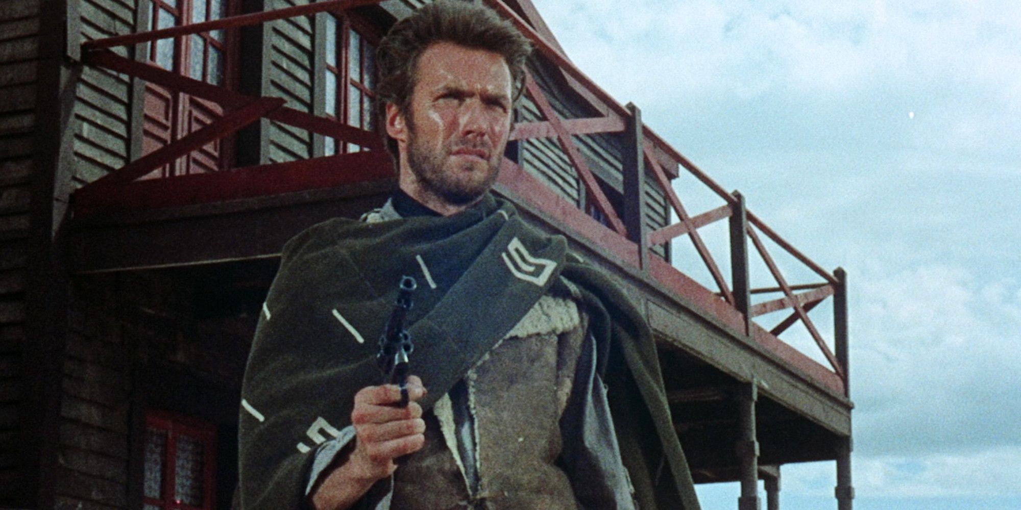 Clint Eastwood points a gun in a scene from A Fistful of Dollars