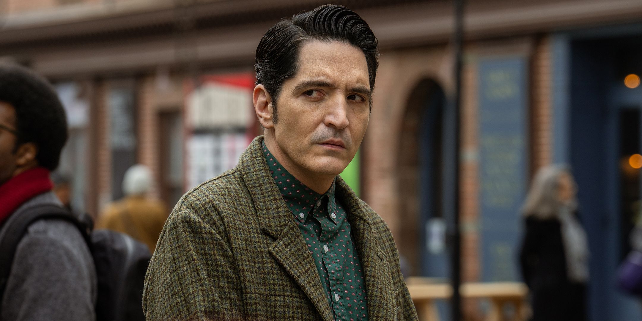 Resurrection Was Just Sealed After Repeating Tragic Mistake By OG Characters David Dastmalchian as Gemini looking suspiciously while standing near a building in Dexter: Resurrection
