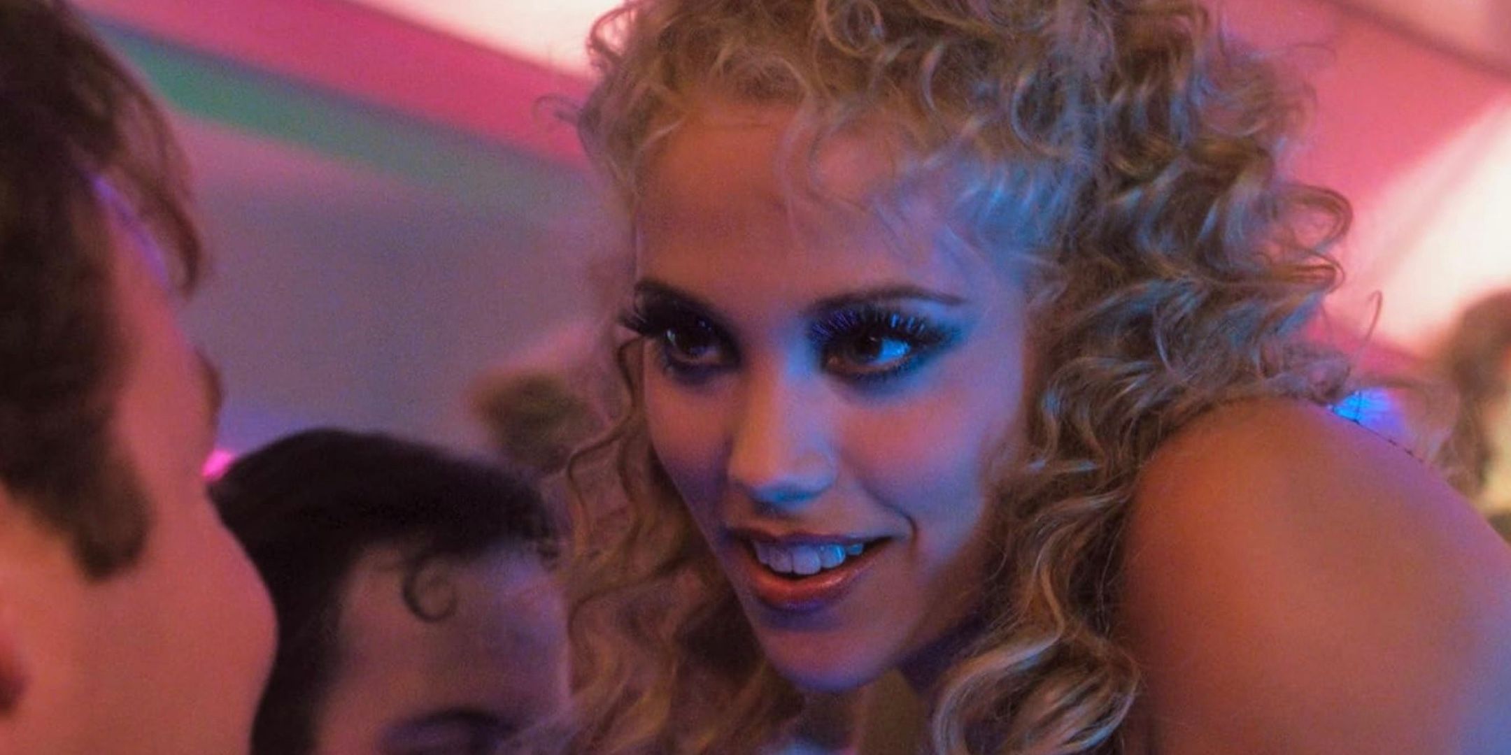 Elizabeth Berkley smiles down at a man.