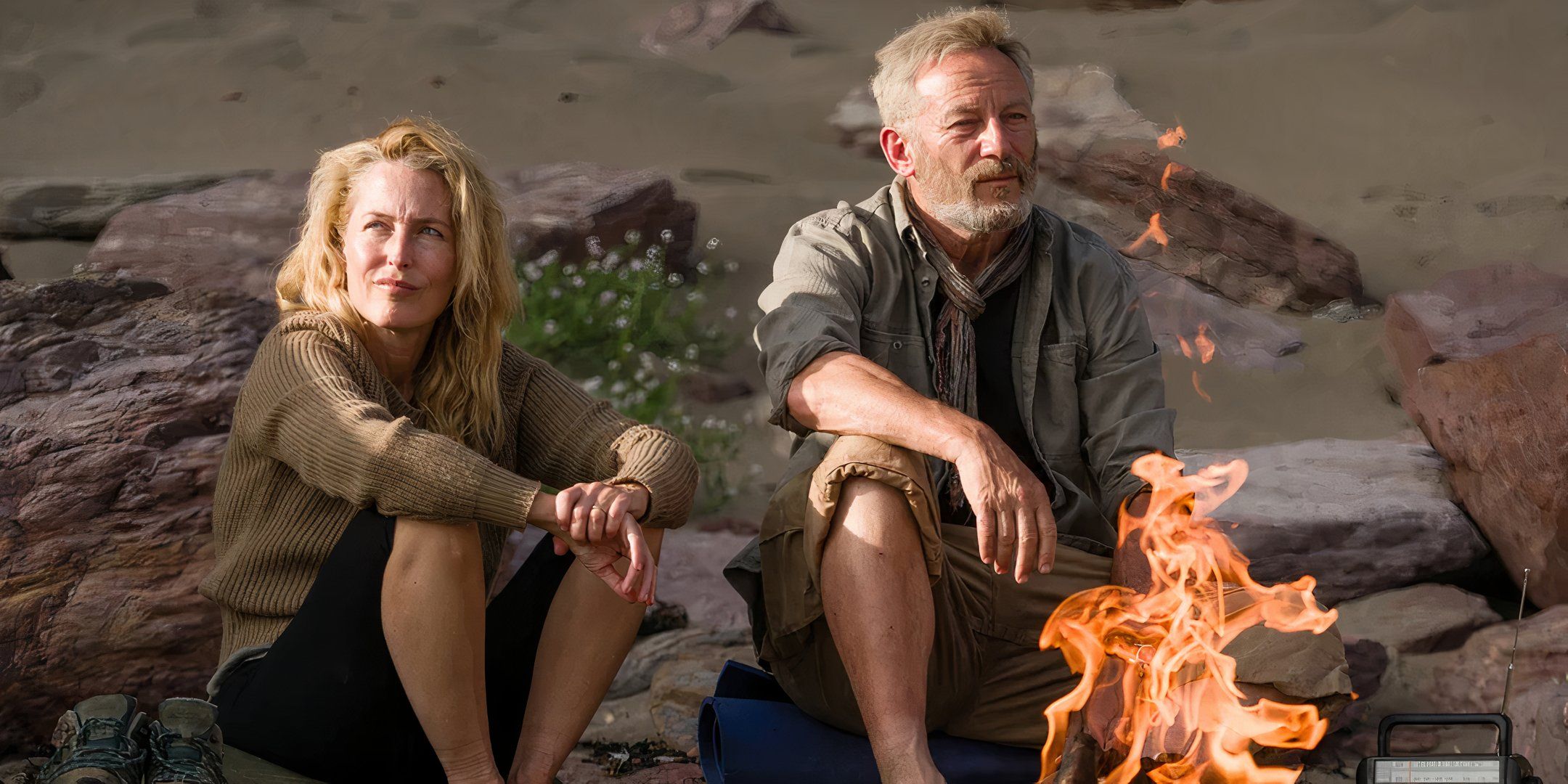 Gillian Anderson and Jason Isaacs in The Salt Path in front of a camp fire