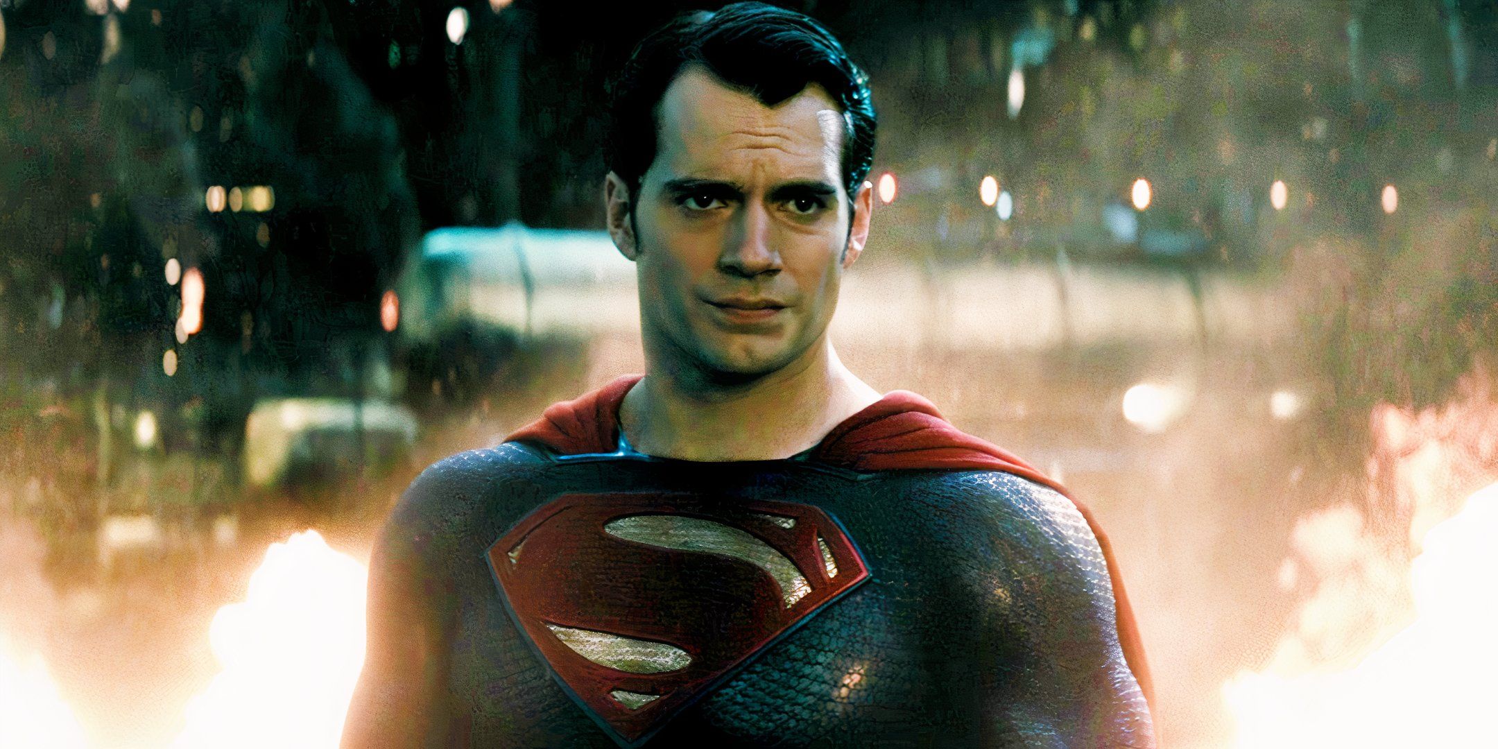 Henry Cavill's Superman looks concerned in front of a blazing inferno in Batman v Superman Dawn of Justice