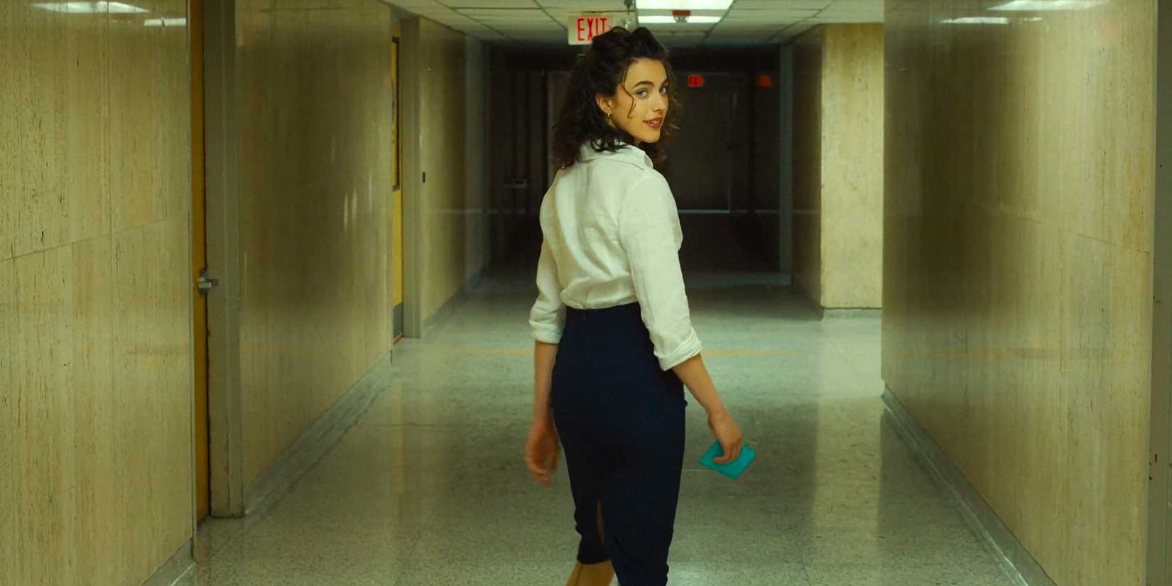Honey O'Donahue (Margaret Qualley) walking down a hallway in Honey Don't!