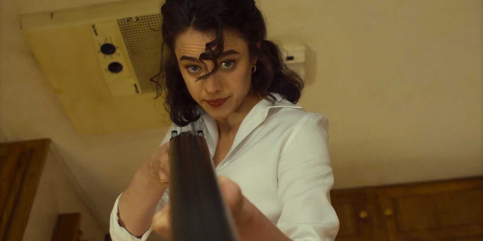 Honey O'Donahue (Margaret Qualley) aiming a rifle in Honey Don't!
