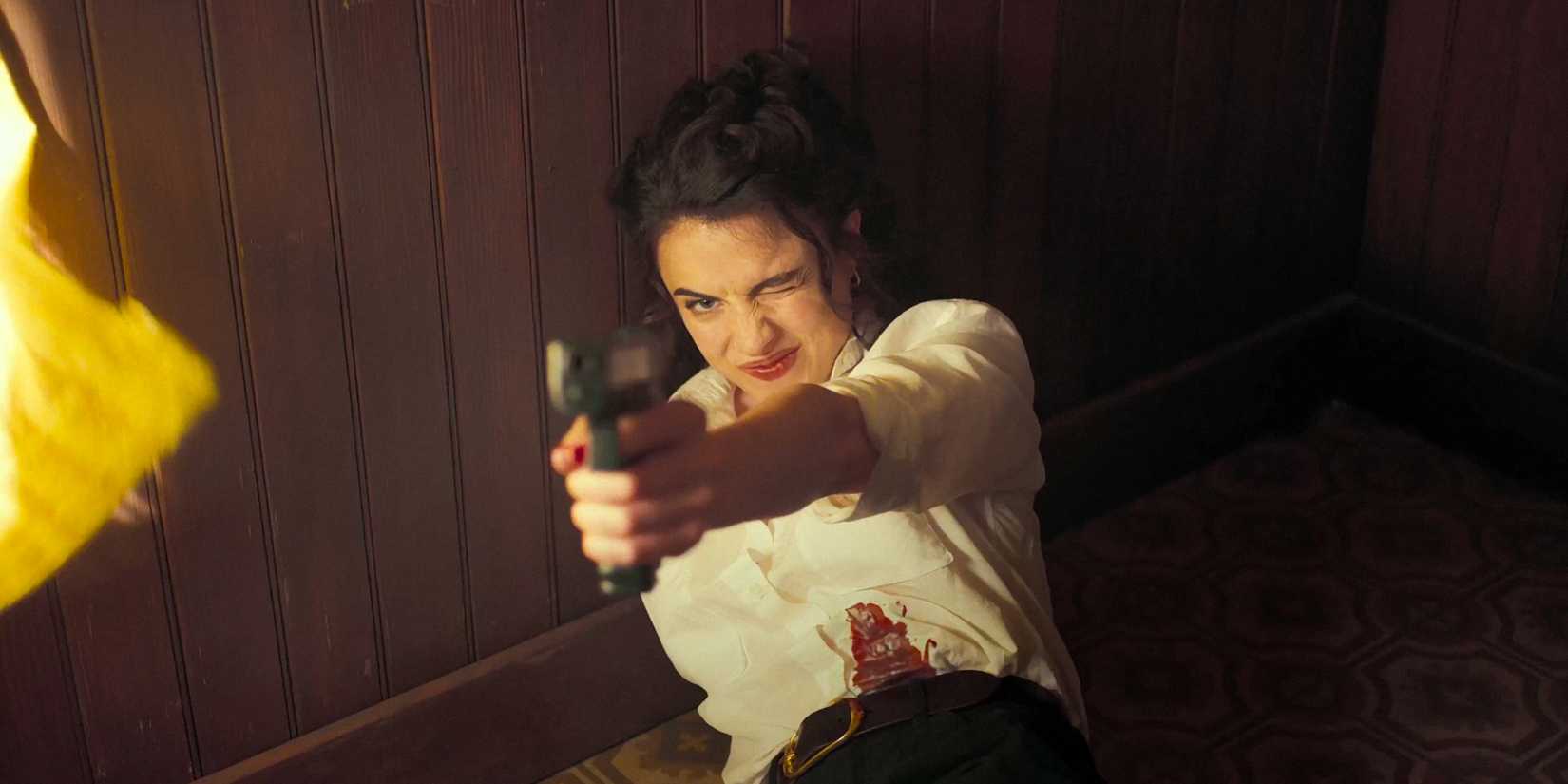 Honey O'Donahue (Margaret Qualley) aiming with a pistol in Honey Don't!