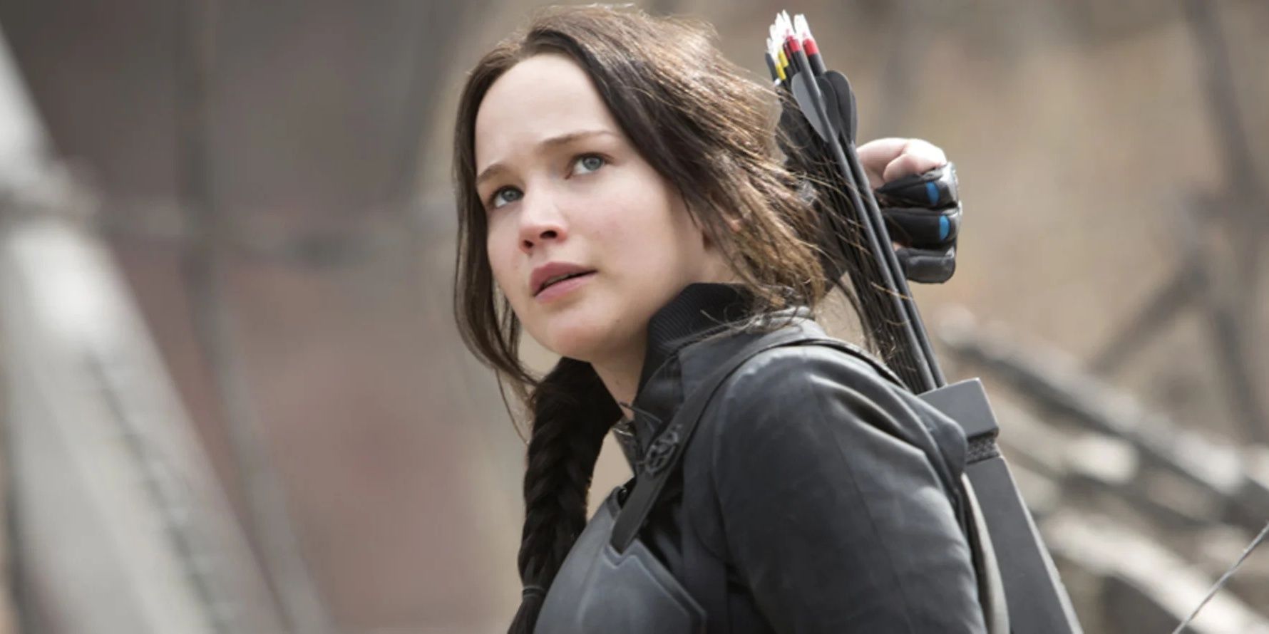 Katniss Everdeen looking up, wearing armors and with a sheath of arrows on her back looking in Mockingjay