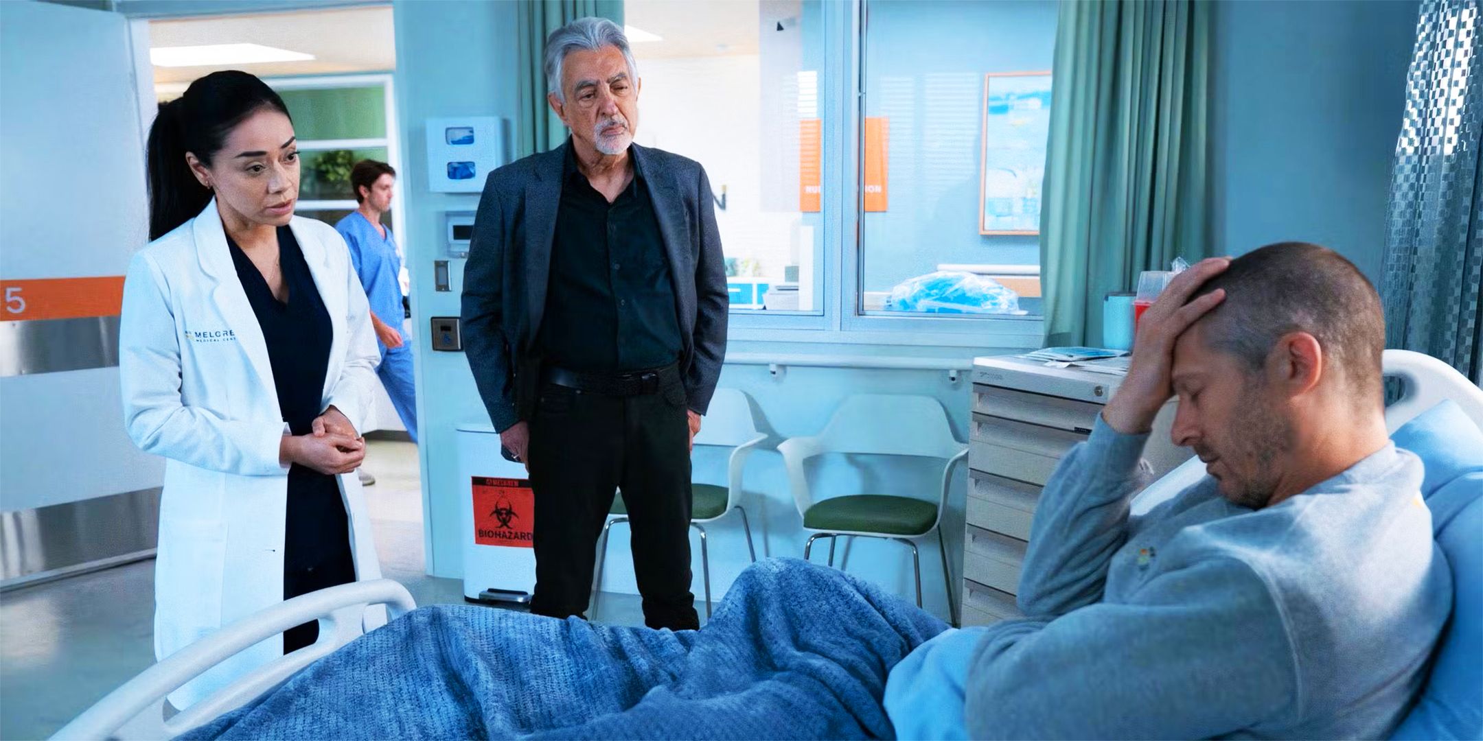 Dr. Ochoa and Agent Rossie stand by Voit's bedside in Criminal Minds: Evolution season 3