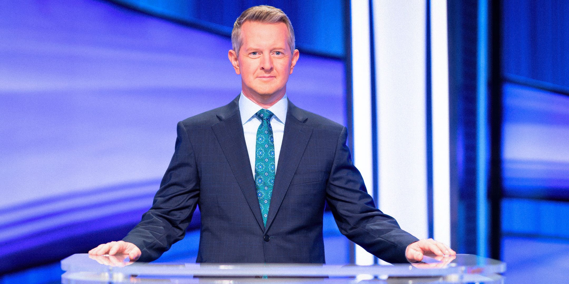 Jeopardy! host Ken Jennings stands behind his podium