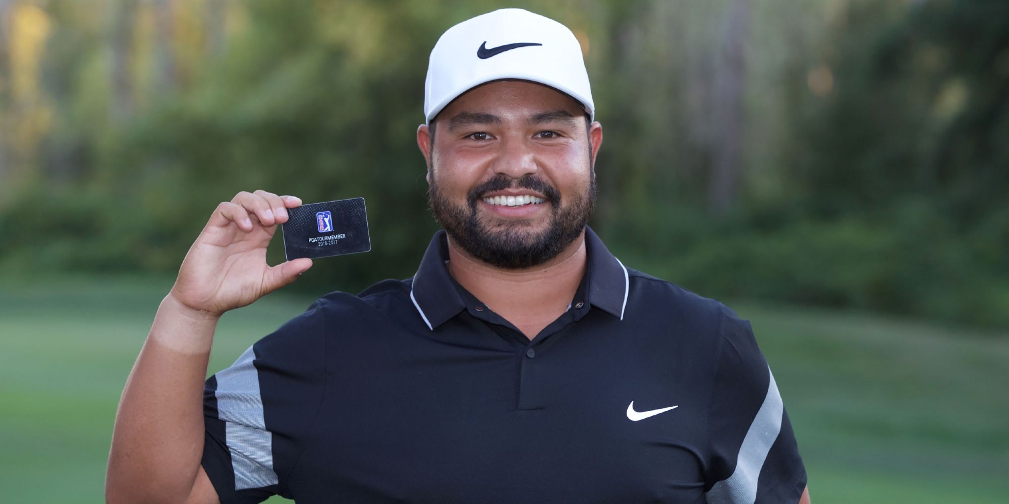 JJ Spaun holding up a PGA Tour card