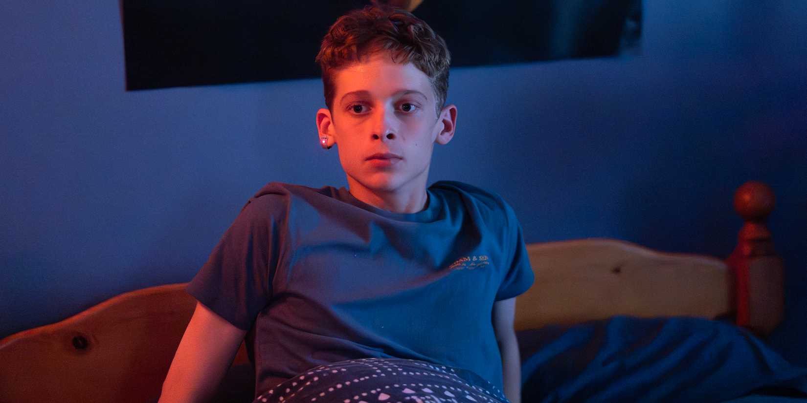Joe Freeman as Luke sitting up worried in his bed in The Institute
