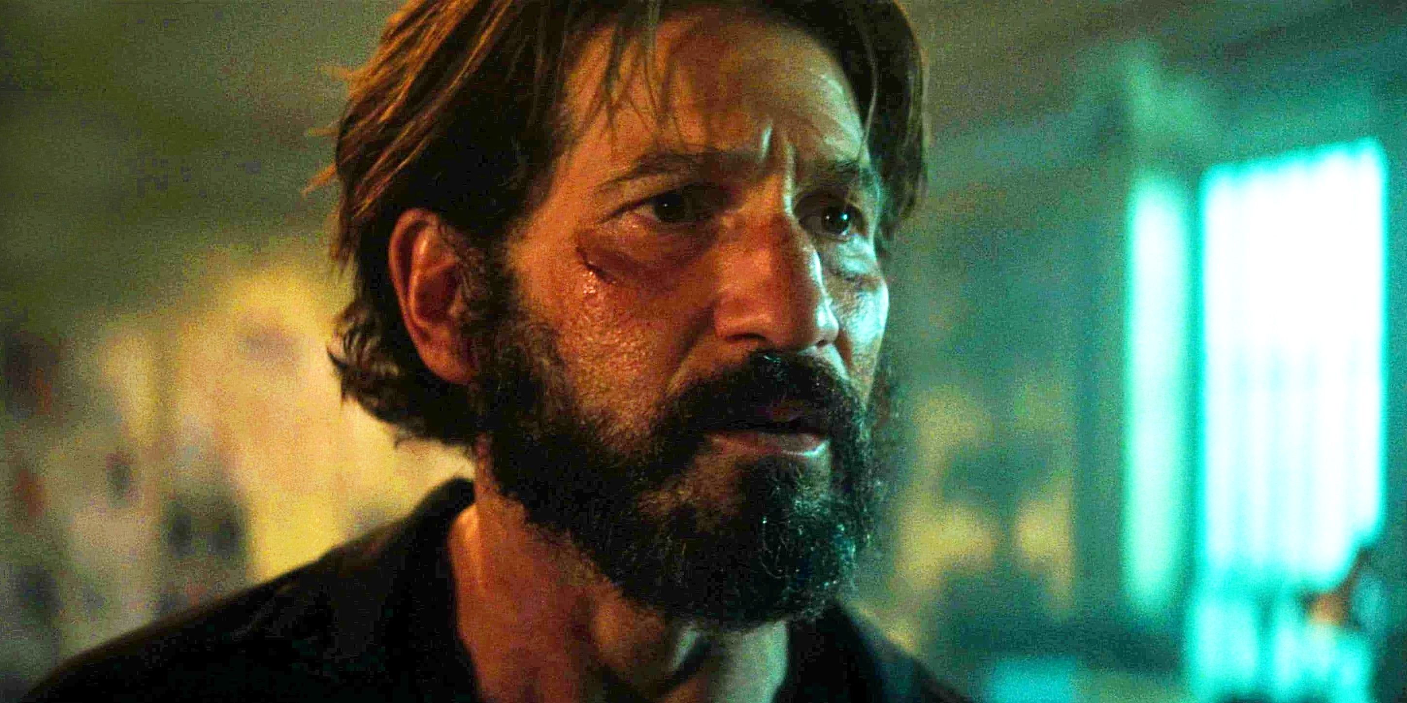 Jon Bernthal with a beard and small cut on his cheek looking seriously at something in Daredevil Born Again