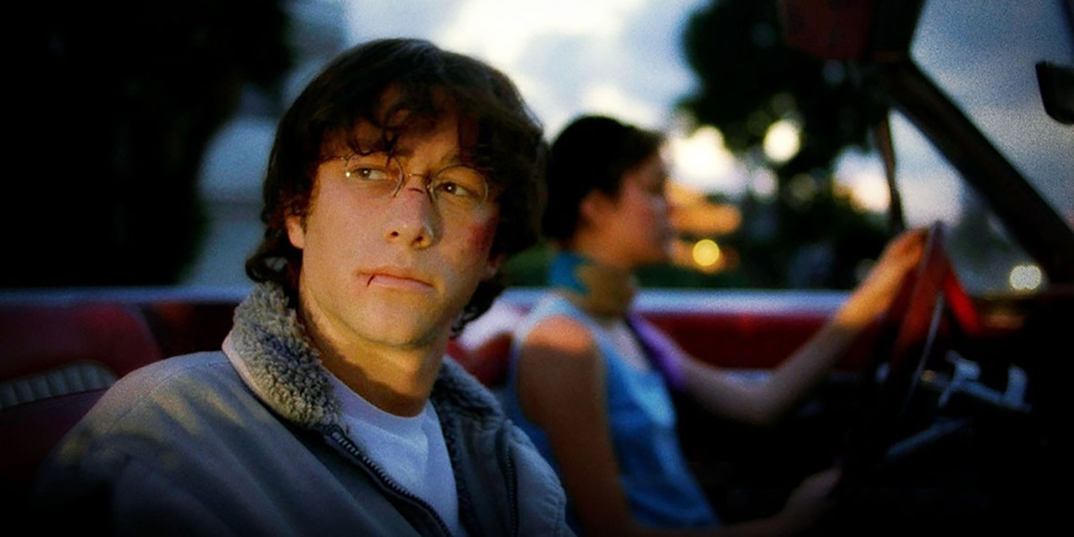 Joseph Gordon-Levitt's Brendan sitting in the pᴀssenger seat of a convertible in Brick