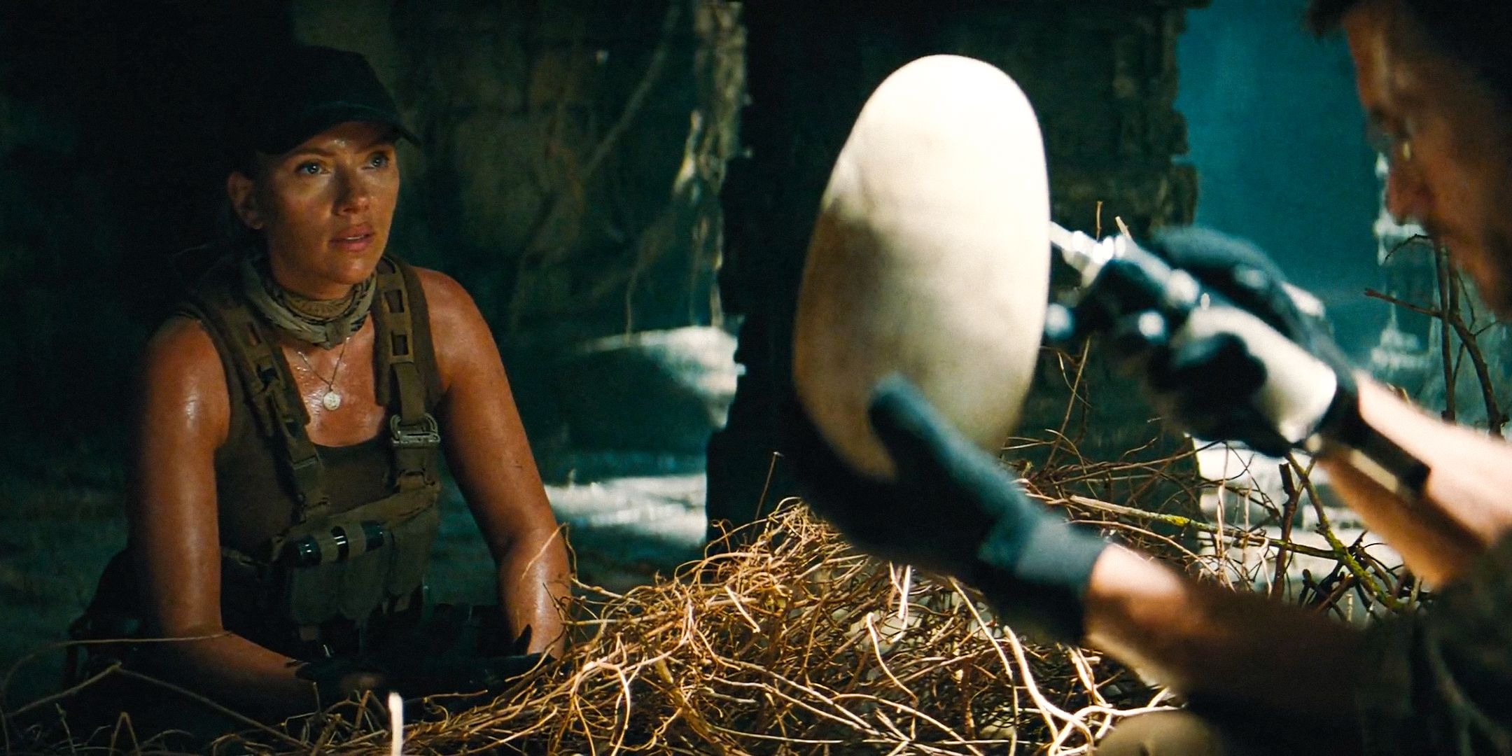 Zora Bennett (Scarlett Johansson) looking at a dinosaur egg held by Dr. Henry Loomis in Jurassic World Rebirth
