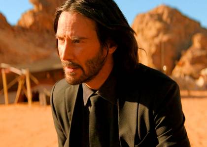 Keanu Reeves as John Wick looking stern in the desert in John Wick Chapter 4