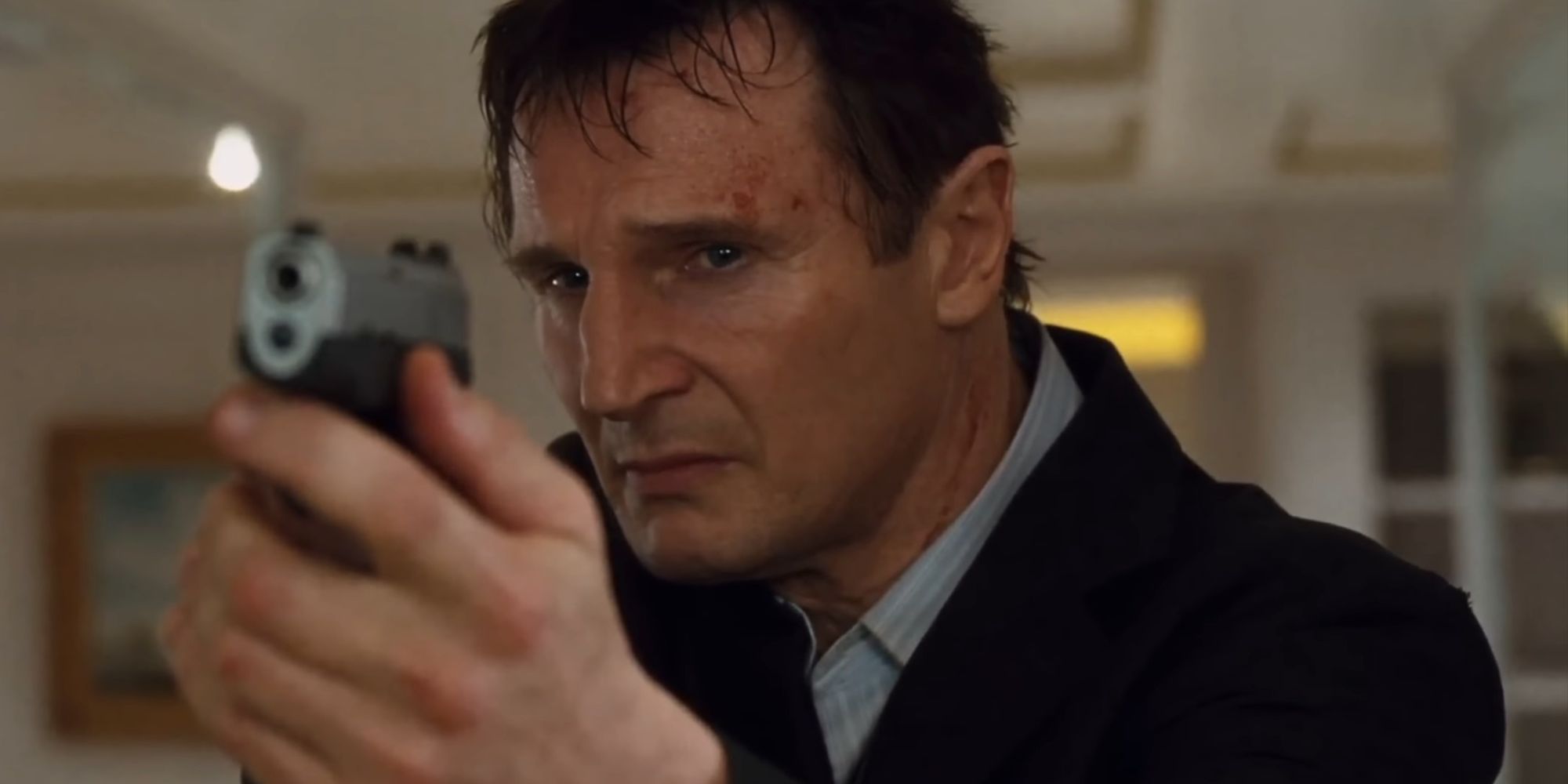 Liam Neeson as Bryan Mills with a gun in Taken