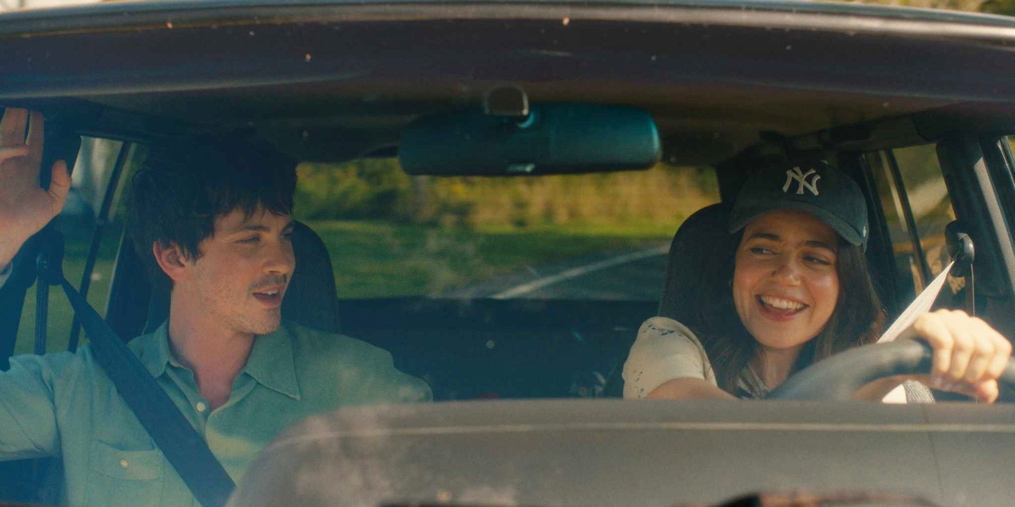 Logan Lerman and Molly Gordon sitting in the front seats of a car in Oh Hi