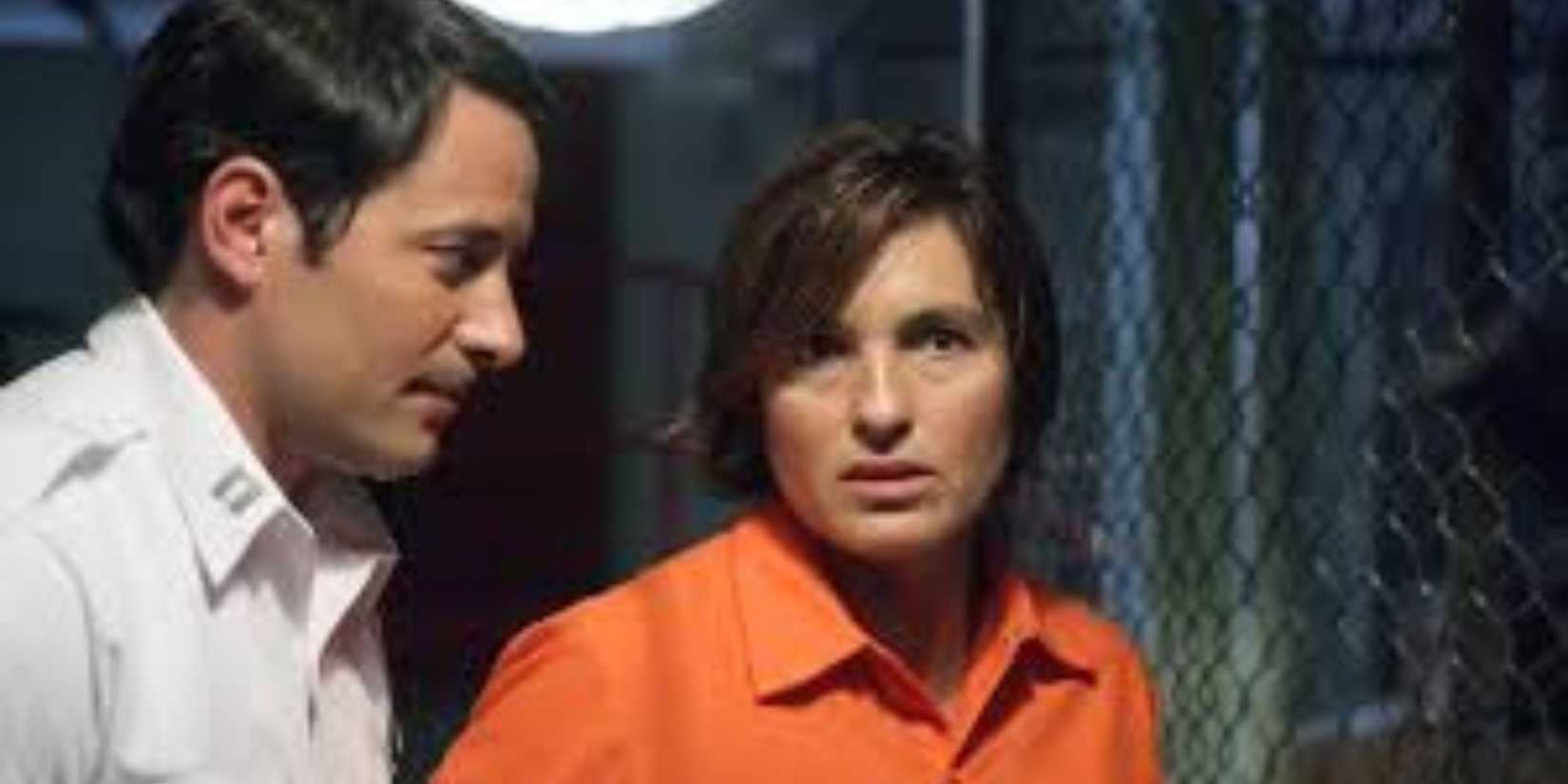 Law & Order: SVU Lowell Harris behind Benson who is in a prison jumpsuit next to a fence