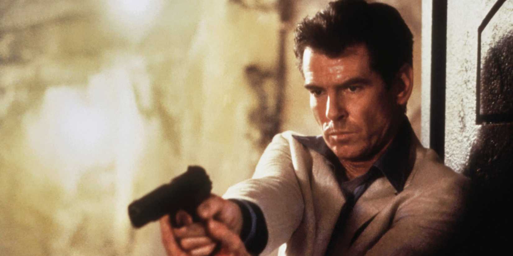 Pierce Brosnan as Bond pointing a gun and looking angry in The World is Not Enough