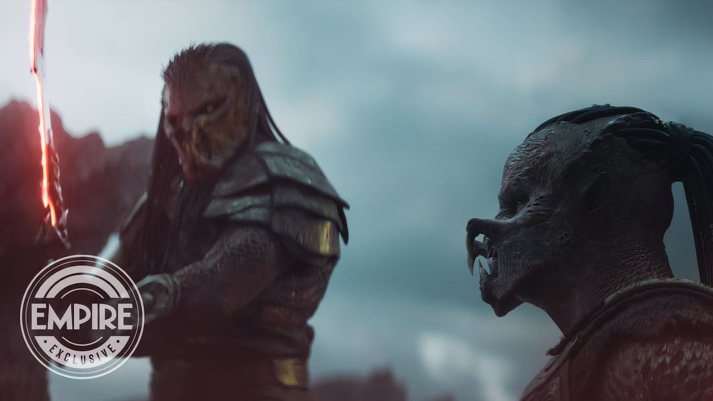 A Predator with a glowing sword looks down at Dek in Predator Badlands