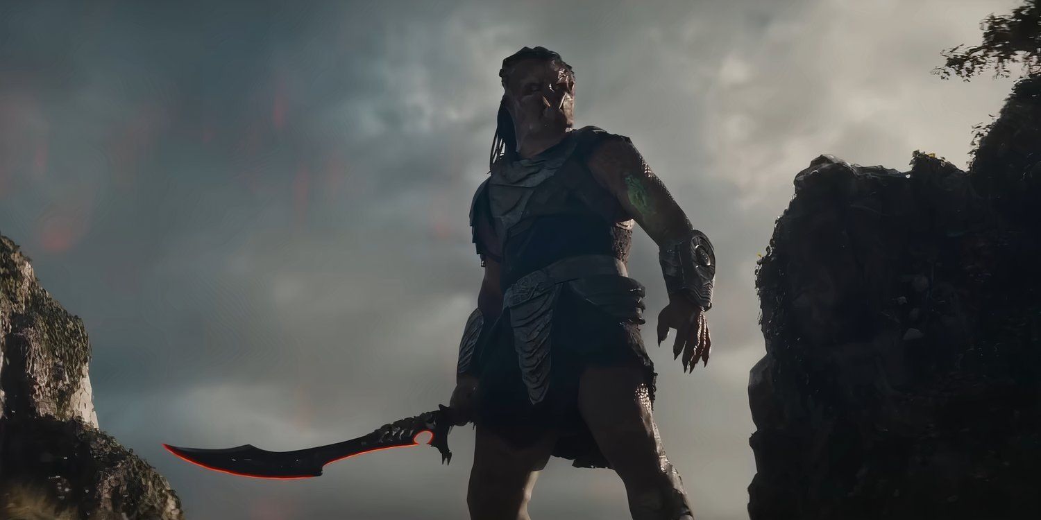 Dek holding a sword on a cliff edge in Predator: Badlands