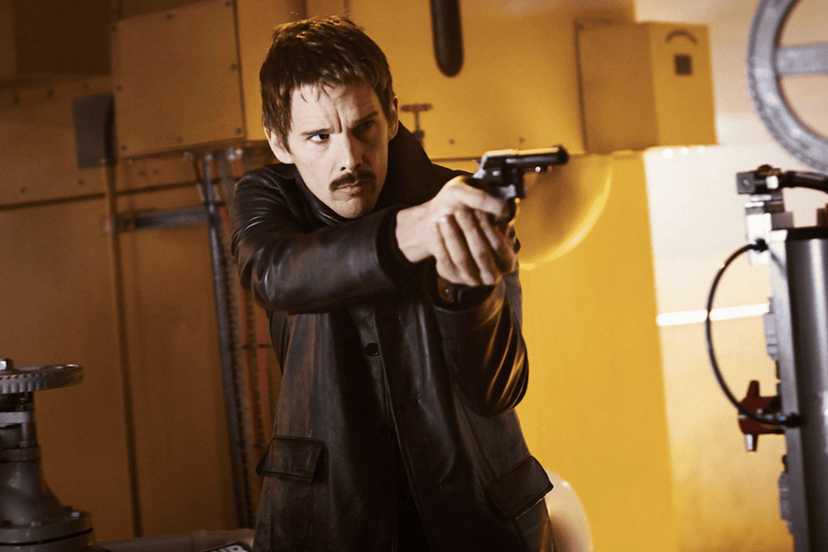 Ethan Hawke points a pistol offscreen in Predestination
