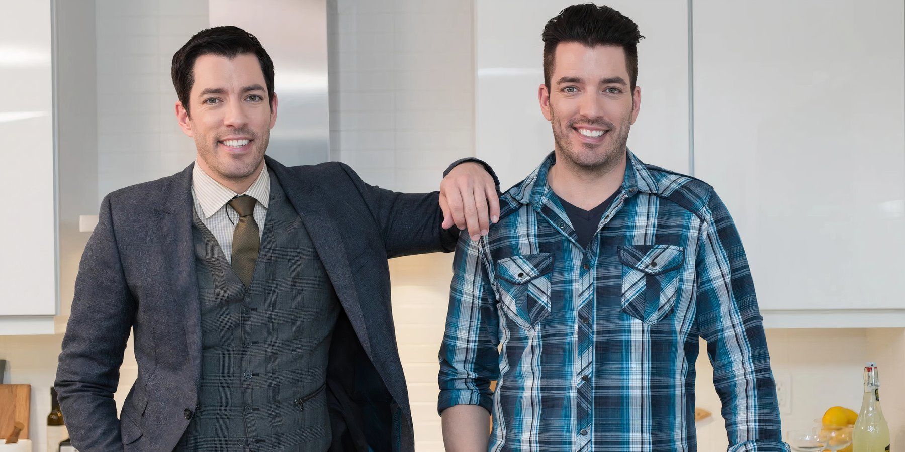 property brothers drew and jonathan scott posing in a home and smiling cropped