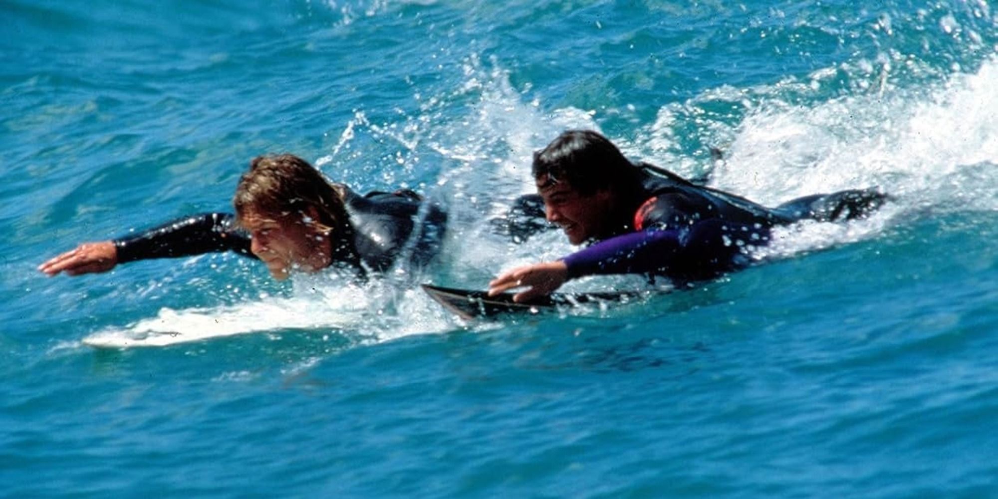 Keanu Reeves as Johnny Utah and Patrick Swayze as Bodhi catching waves in Point Break