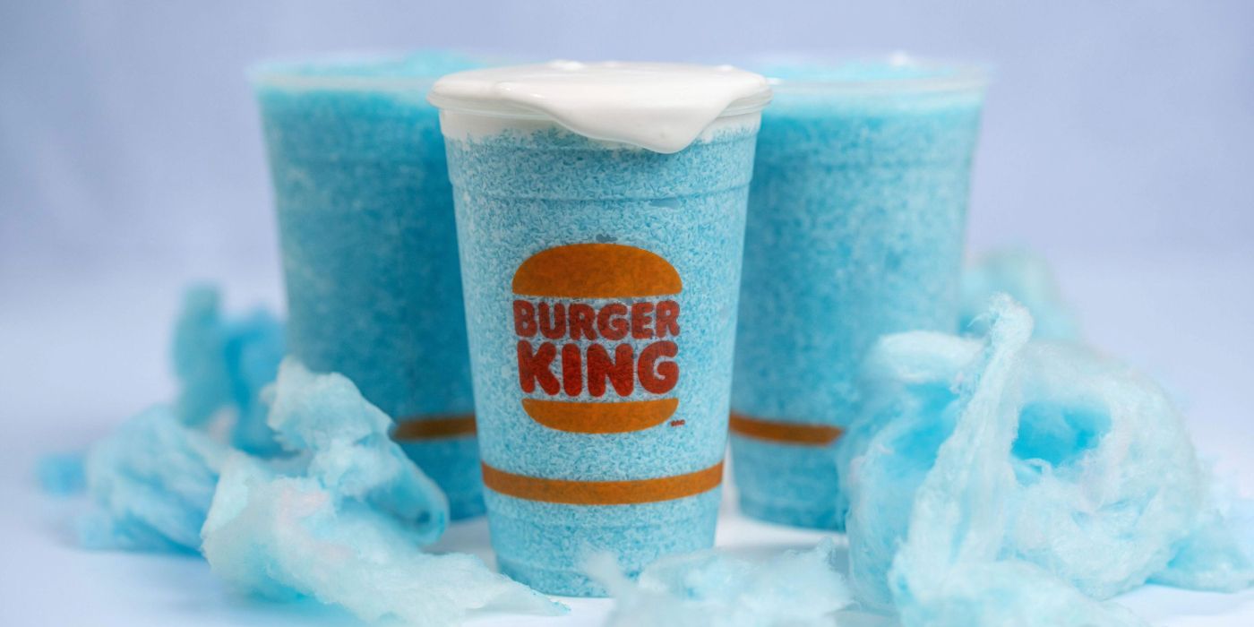 Cups of Burger King's blue cotton candy beverage with whipped cream on top