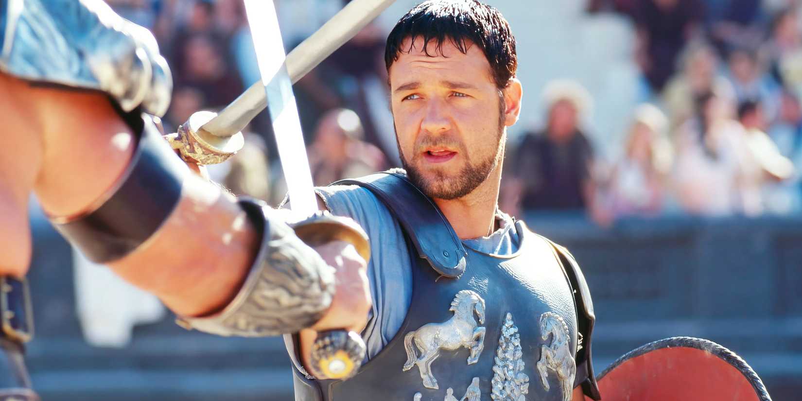 Russell Crowe holding a sword in a battle scene in Gladiator