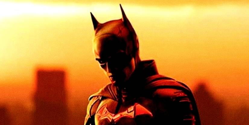 Robert Pattinson's Dark Knight stands in front of a sunset in The Batman