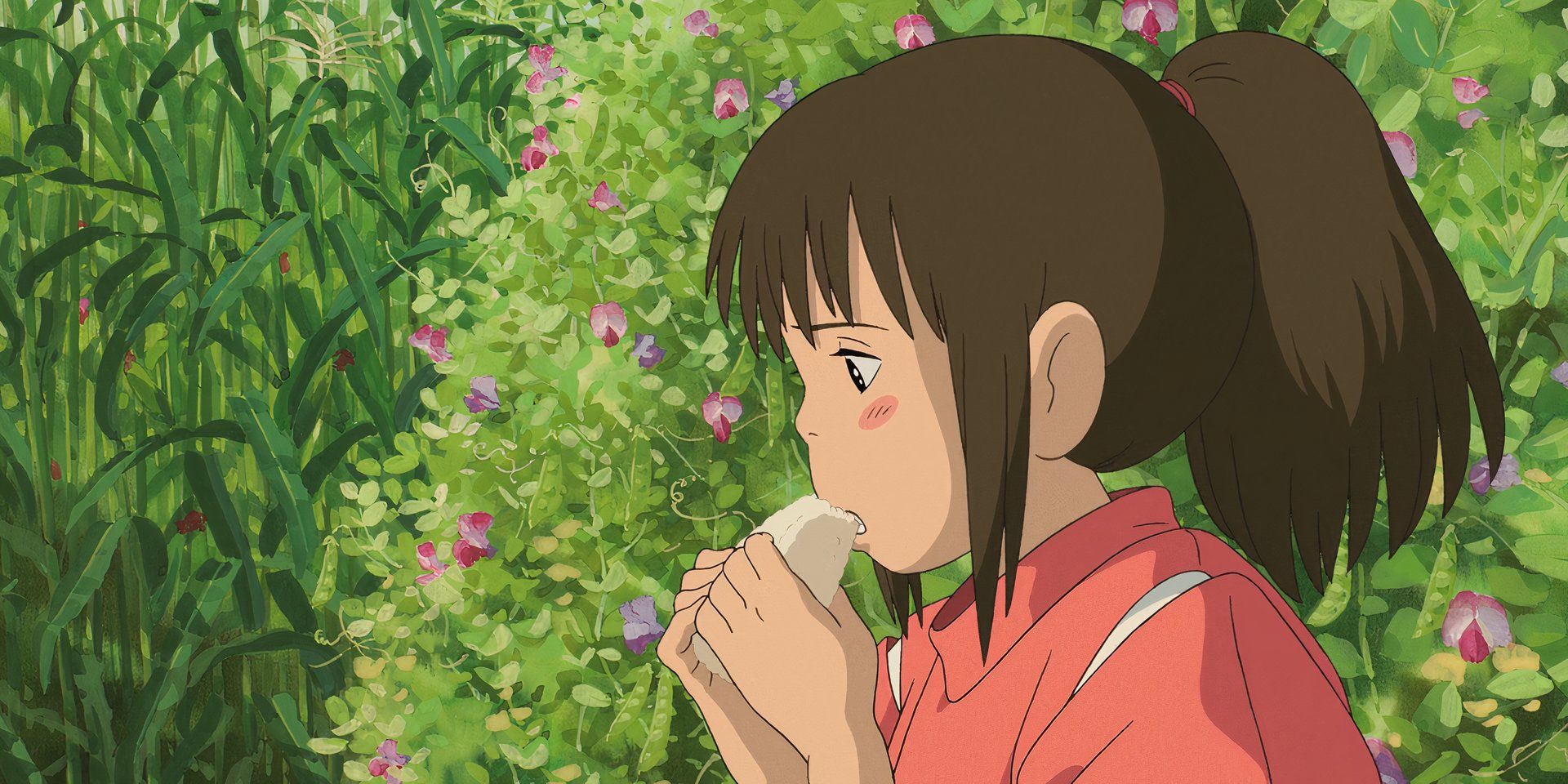 Chihiro che mangia emozionata un onigiri
