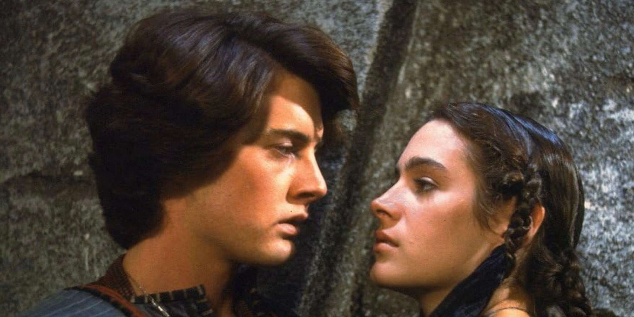 Kyle MacLachlan looks down at Sean Young. 