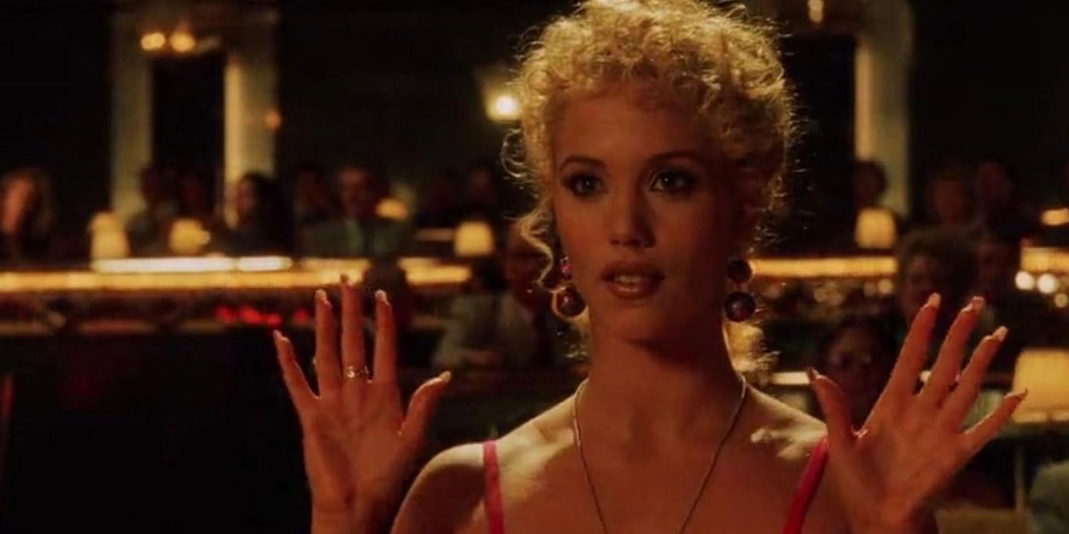 Elizabeth Berkley holds her hands up. 