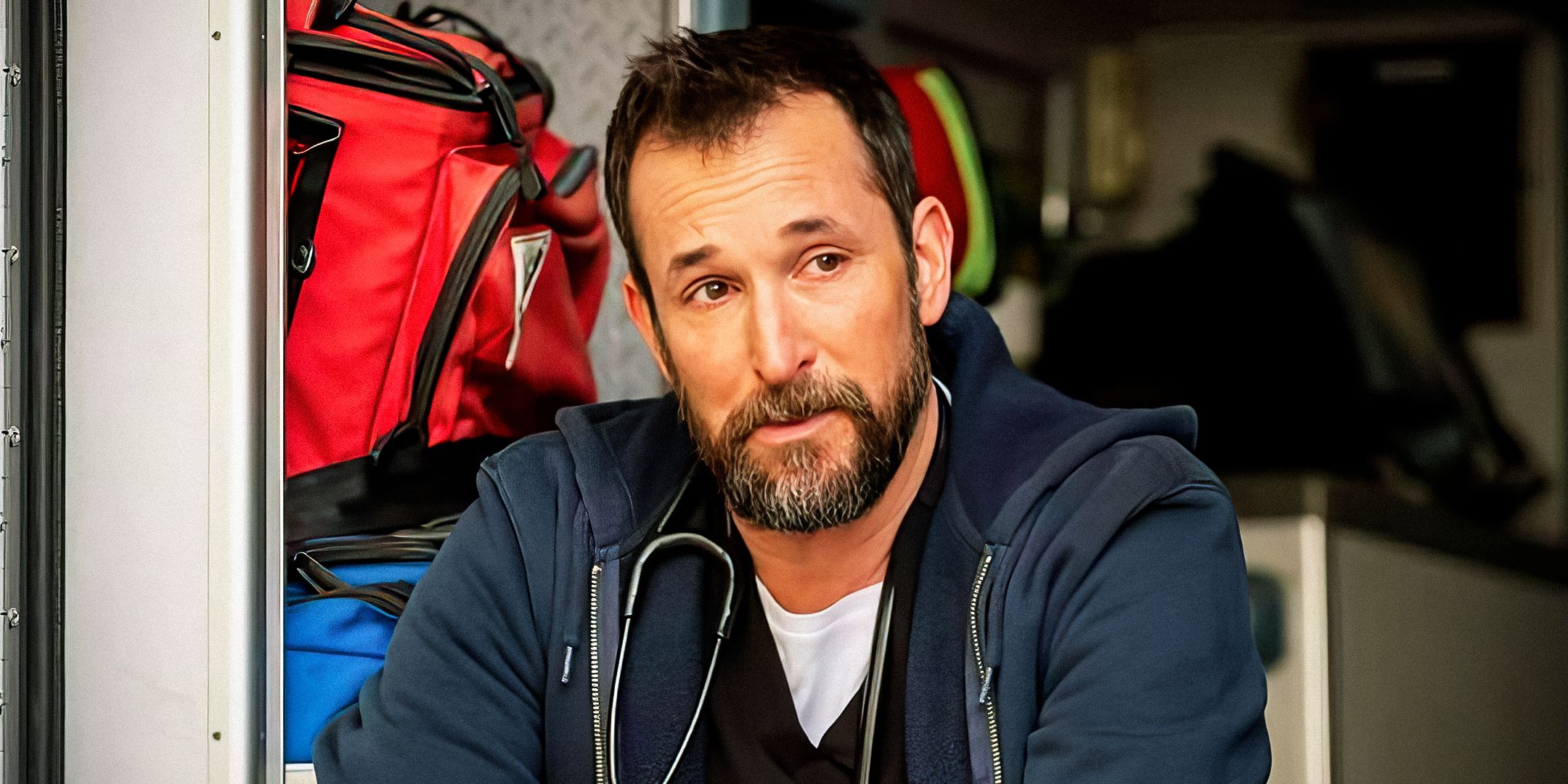 Noah Wyle as Dr. Robby sitting in the back of an ambulance