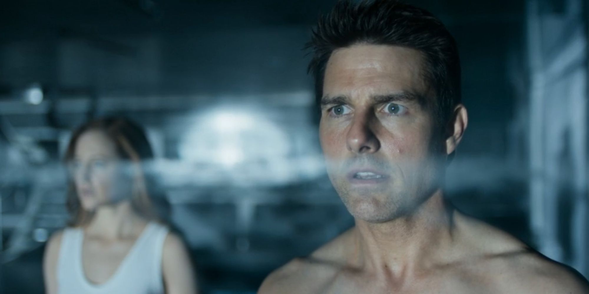 Tom Cruise as Jack Harper and Andrea Riseborough as Victoria Olsen looking out the window in Oblivion
