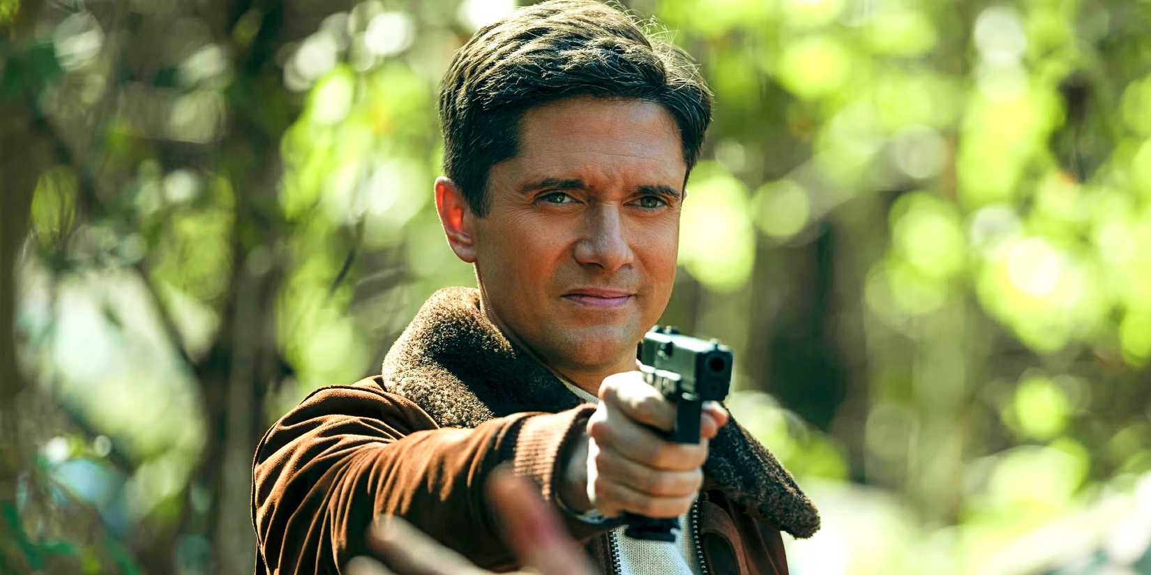 Topher Grace pointing a gun in The Waterfront