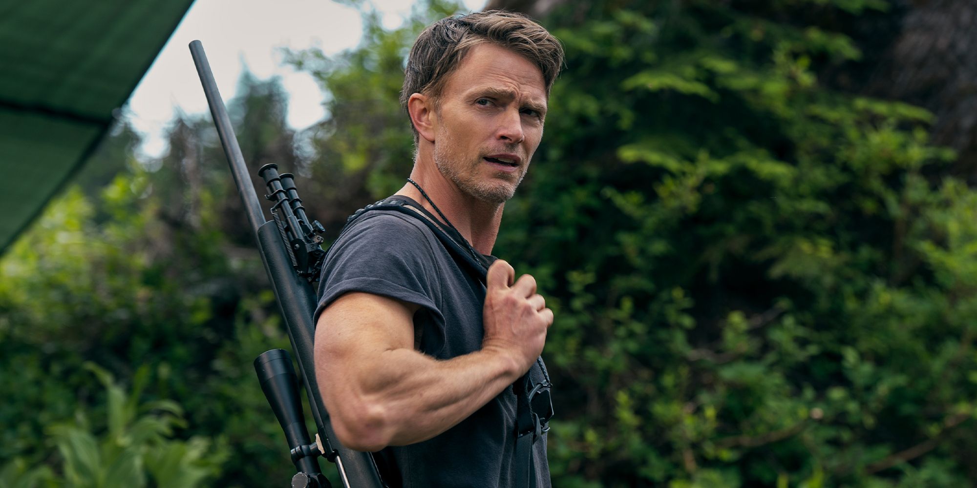 Wilson Bethel carrying a firearm over his shoulder and looking to the side in Untamed