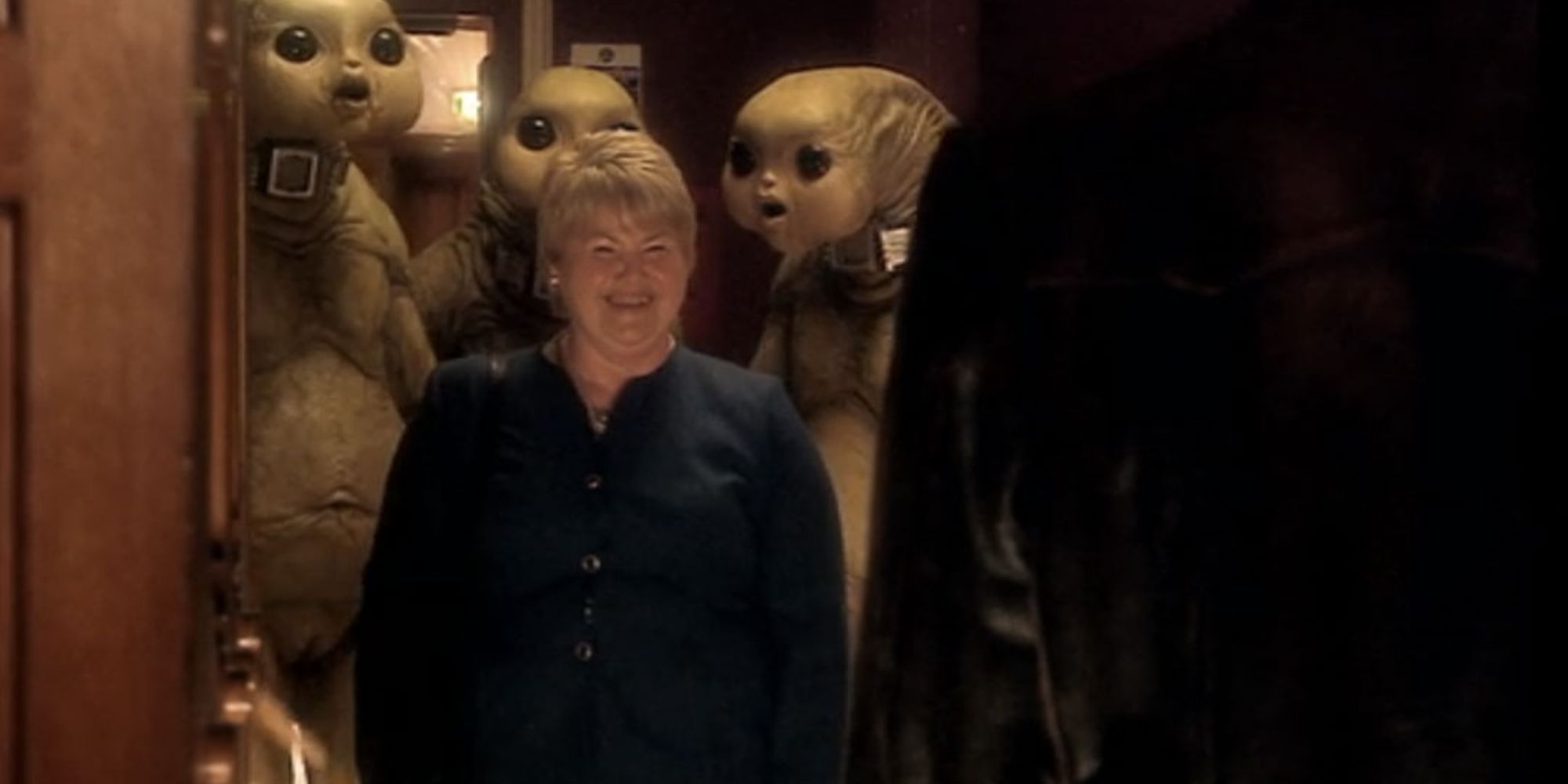 Margaret surrounded by three Slitheen outside of the cabinet office, as they threaten the Ninth Doctor, in the Doctor Who season 1 episode "World War Three."