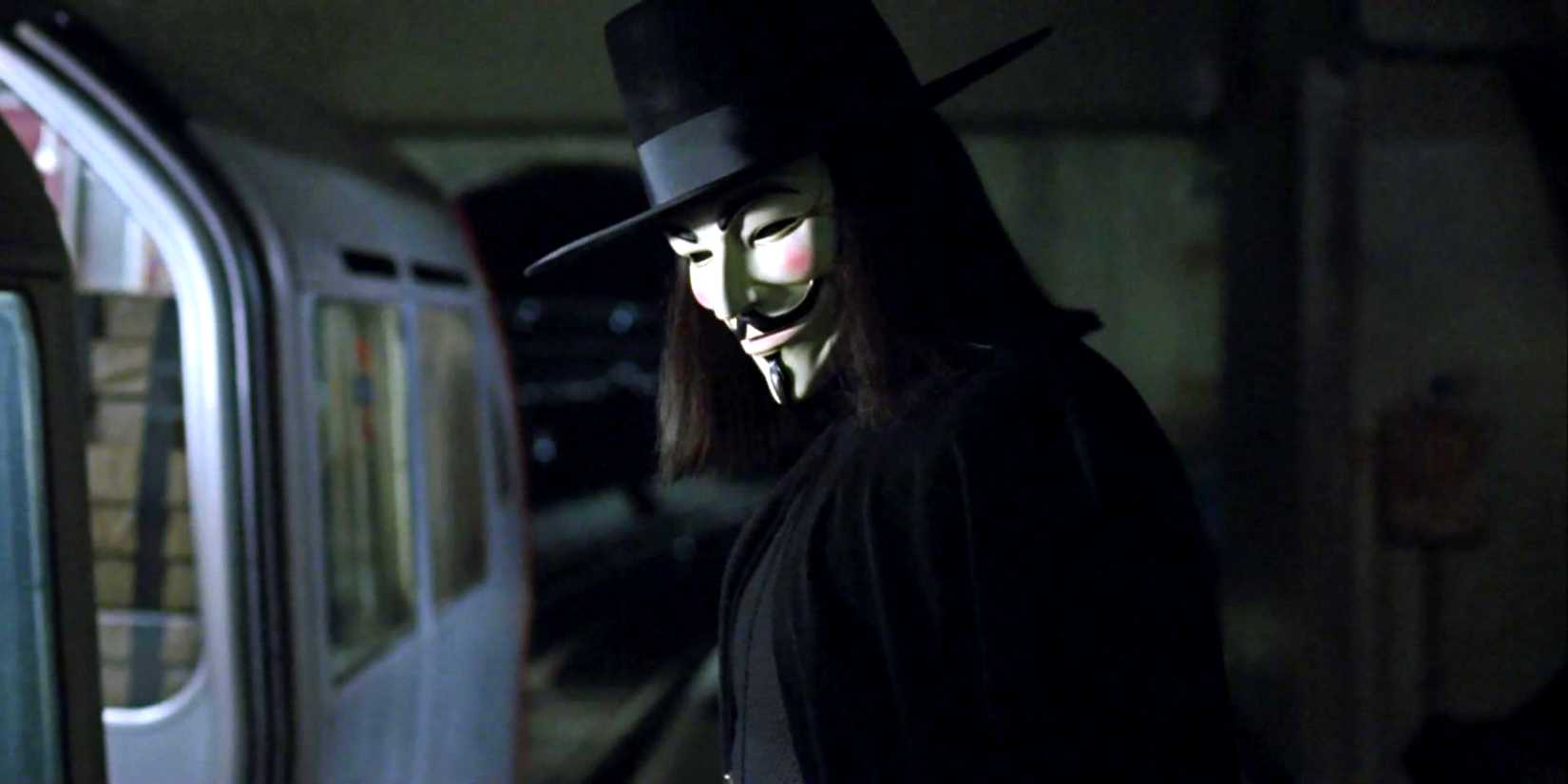 V looking over his shoulder standing next to a subway in V for Vendetta