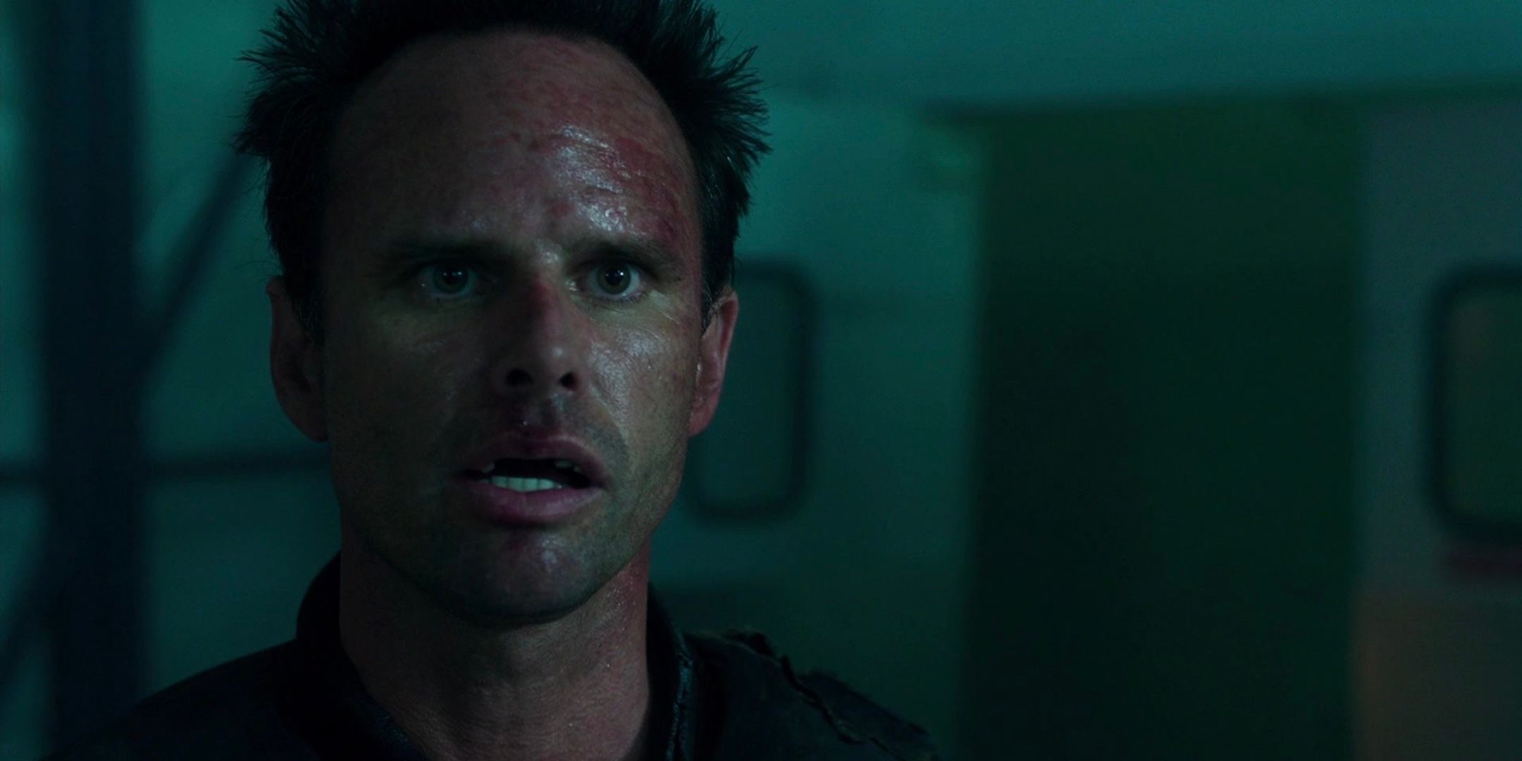 Walton Goggins looks forward with a stunned expression. 