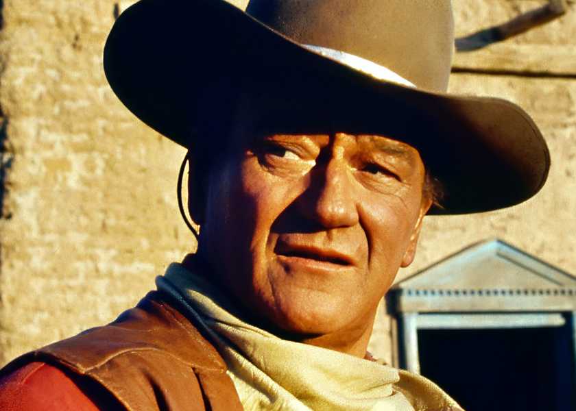John Wayne looks over to the side. 