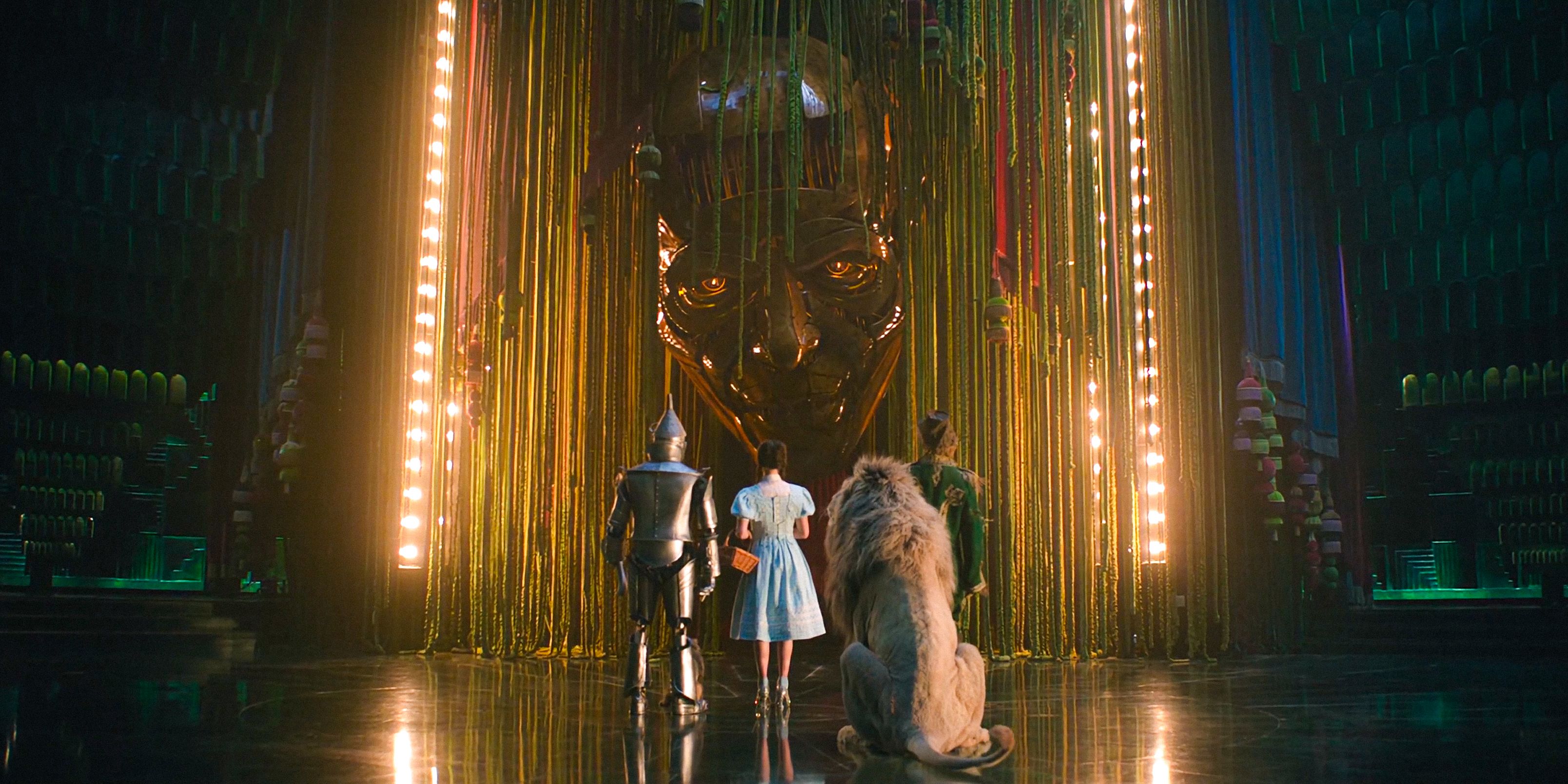 The Tin Man, Dorothy, the Lion, and the Scarecrow standing before the Wizard of Oz in Wicked: For Good