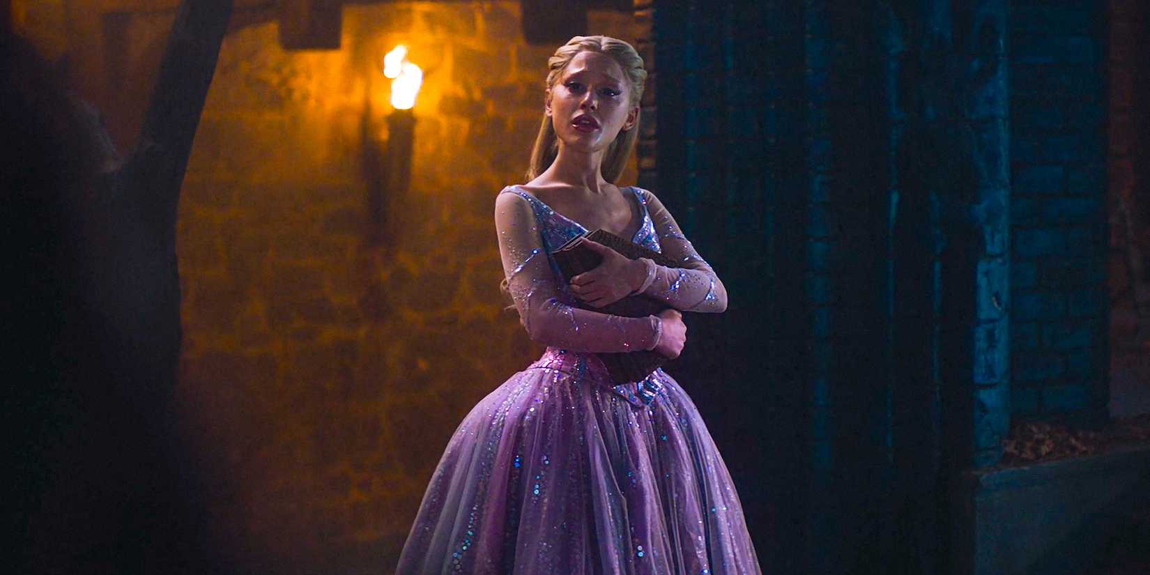 Glinda (Ariana Grande) clutching a book to her chest in Wicked: For Good