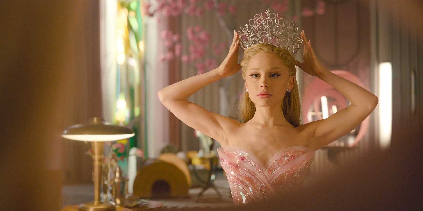 Glinda (Ariana Grande) carefully putting on her crown in her room in Wicked: For Good.