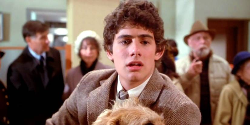 Zach Galligan as Billy holding his dog in Gremlins