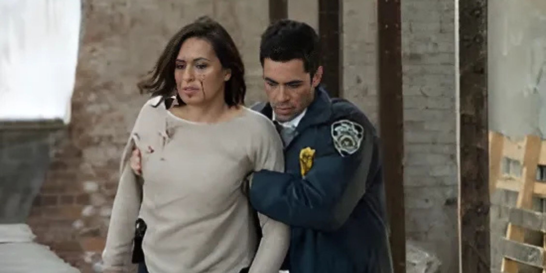 Amaro walking with his arms around Benson, who has blood on her face, in Law & Order: SVU
