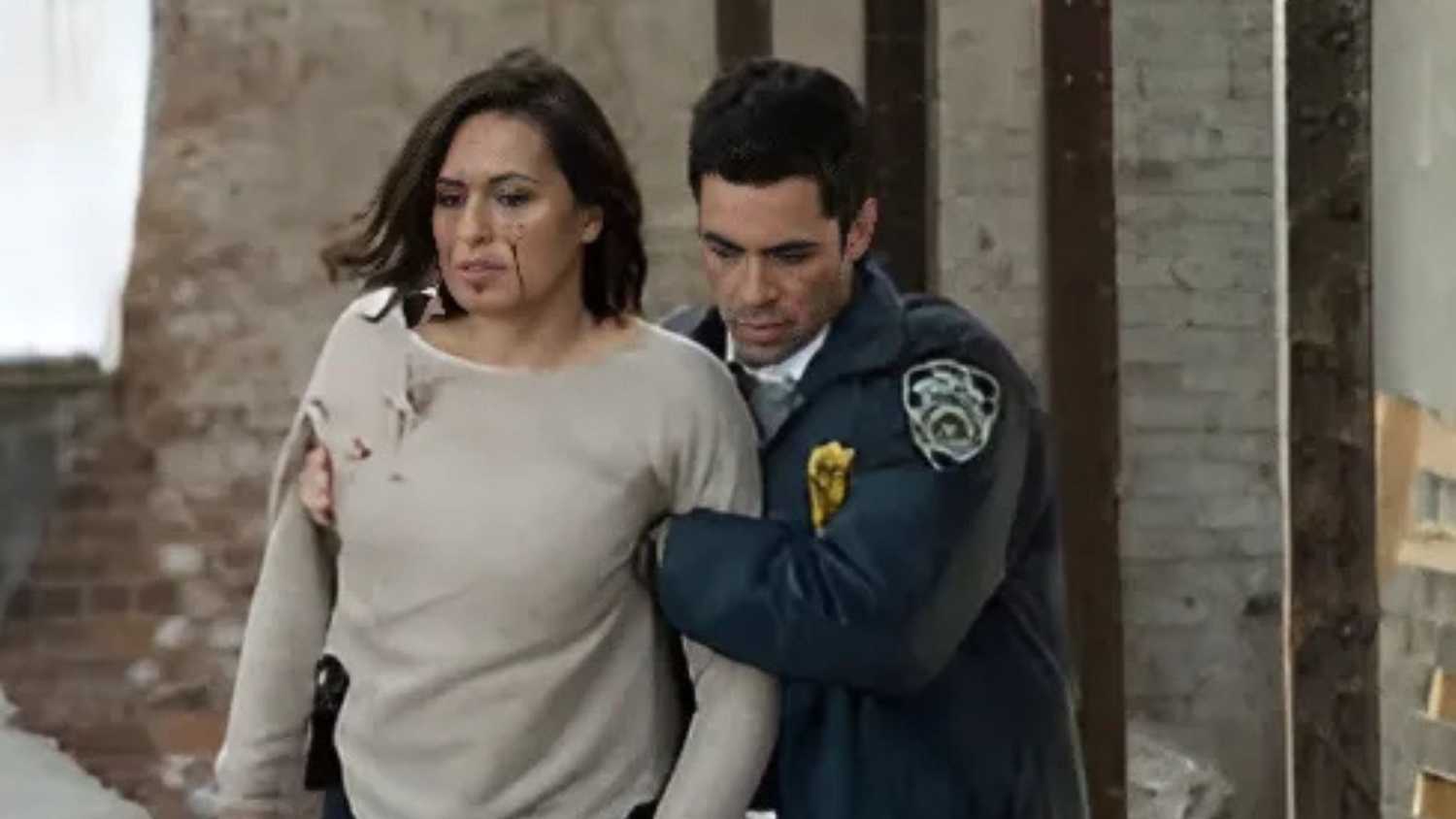 Amaro walking with his arms around Benson, who has blood on her face, in Law & Order: SVU