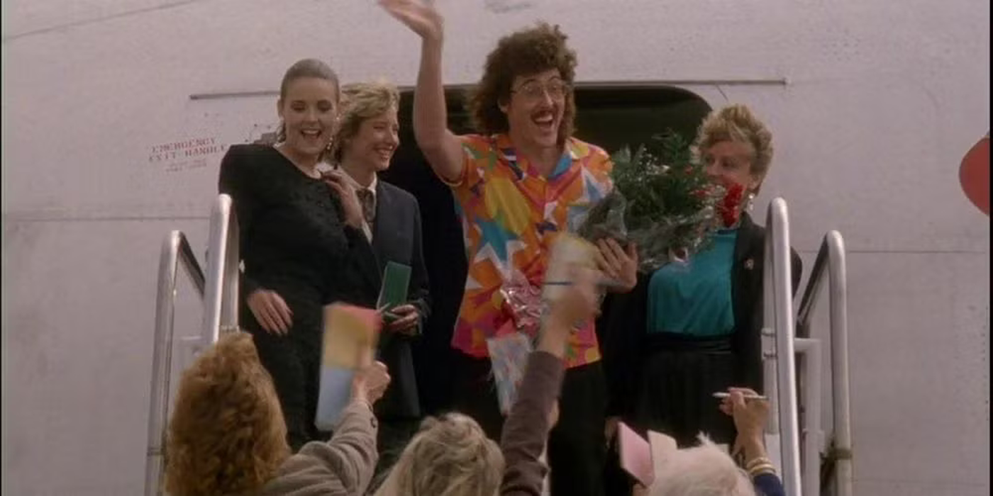 Weird Al waving on the steps of an airplane in The Naked Gun (1988)