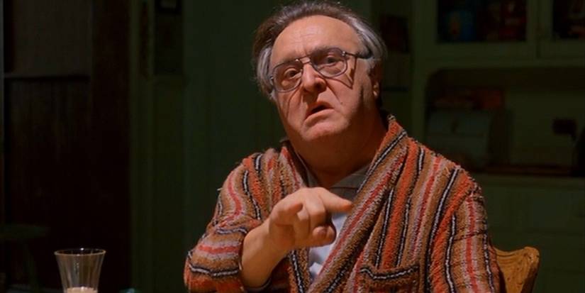 Cosmo wearing a dressing gown and pointing off-screen in Moonstruck